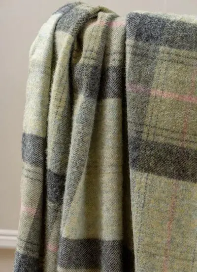 Close up of green plaid wool throw draped across wooden chair